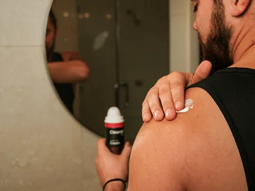 man applying CBD cream with heat on his shoulder for pain relief
